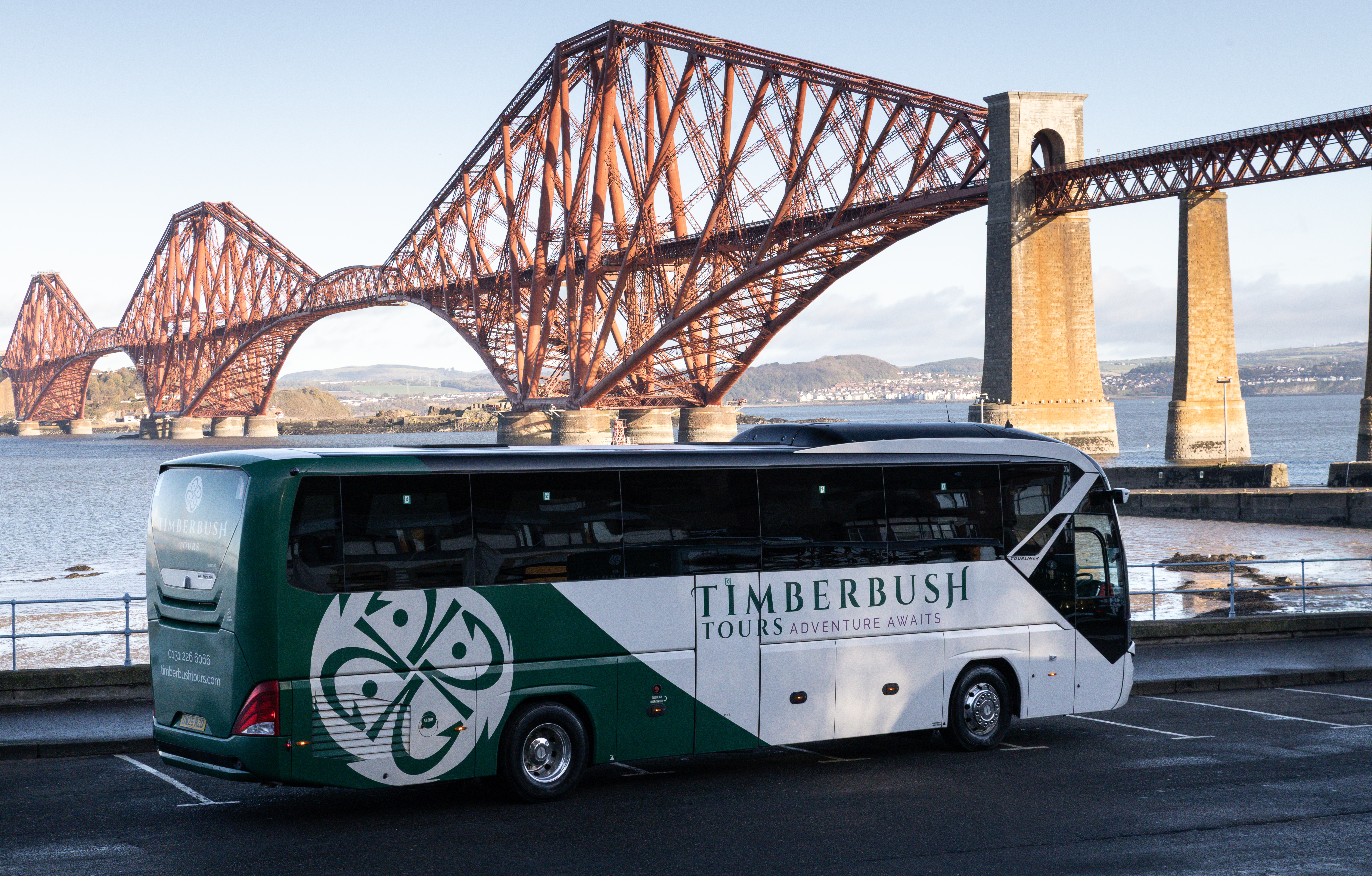 A Large Coach with the Forth Bridge in the backgorund