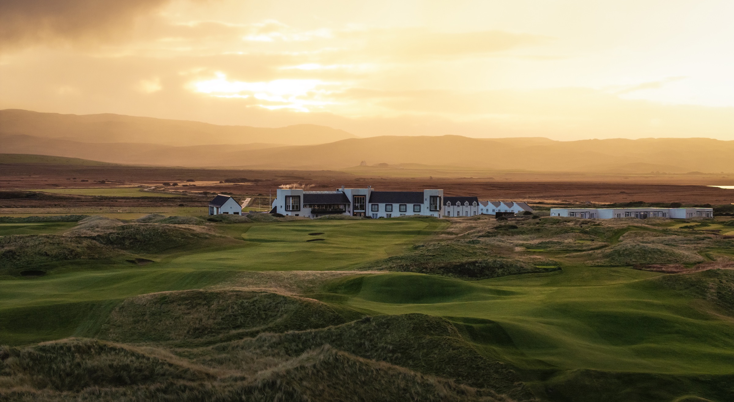 An image of the Machrie hotel at sunset.